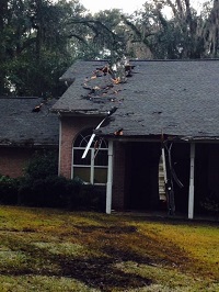 Roof damage sustained by a tree felled by gusty winds in Tallahassee, FL on Trescott Drive in Tallahassee, FL on December 24, 2015.
