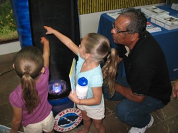 Fred Vega explains how a waterspout forms for two children at Su Clinica Familiar, Harlingen