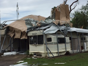 Crumpled tin roof and other mobile home construction surrounding an RV at the Chimney Park mobile home resort in Mission, TX on May 31, 2016, around 1121 PM
