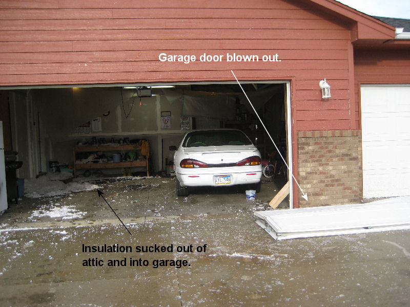 Garage door blown out and insulation in garage.