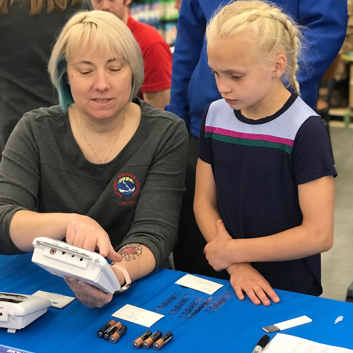 Amy teaching a child about a weather radio