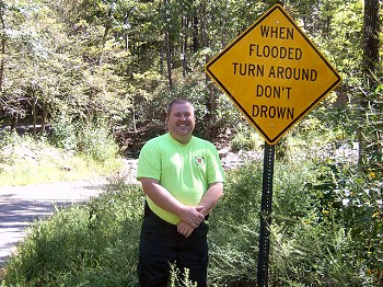 Johnson County Emergency Manager Josh Johnston stands next to a Turn Around Don't Drown sign along County Road 3198 at the north end of Horsehead Lake (Johnson County) on 09/08/2011.