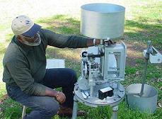 Picture of a technician performing maintenance on a rain gage - click to enlarge
