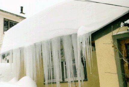 Melting snow frozen into a near sheet on a roof.