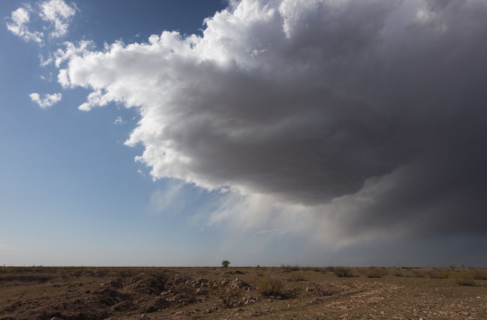The updraft base of a low precipitation storm is seen over the plains of Chaves county. Very little rainfall is inferred from the fuzzy and transparent rain shaft in the right side of the image.