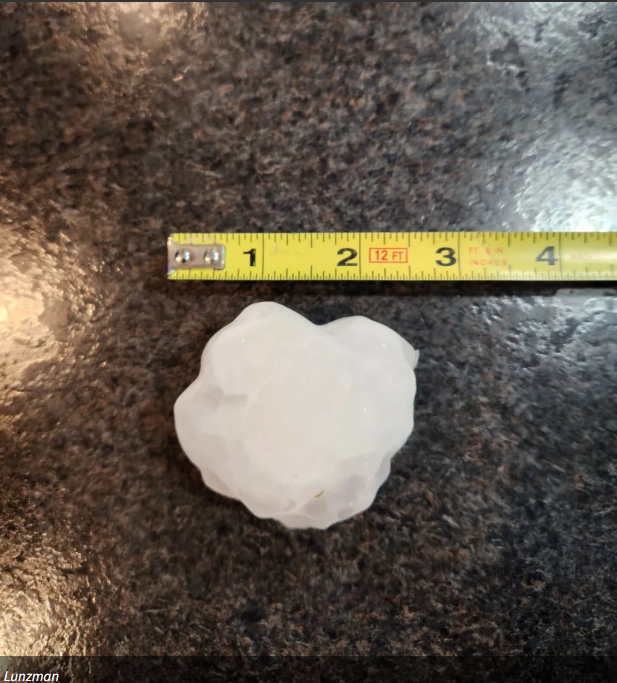 Hail stone a little larger than 3.5 inches next to tape measure