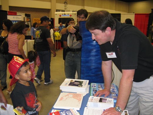 Photo of Forecaster Ryan Vipond talking weather safety with a youngster at the Hidalgo County Dare to Prepare Readiness Expo, July 11, 2009 (Click for larger image)