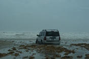 Jeep in sand with waves crashing (click to enlarge)