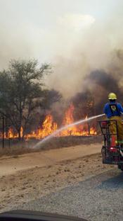 Firefighters applying water to burning grasses on the SMAC Ranch, June 18th 2011 (click to enlarge)