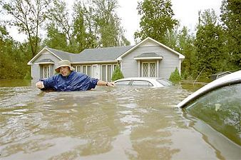 Man wading through chest deep flood waters