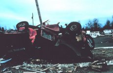 Tornado crushes and rolls farm vehicle, pinning it against a post.