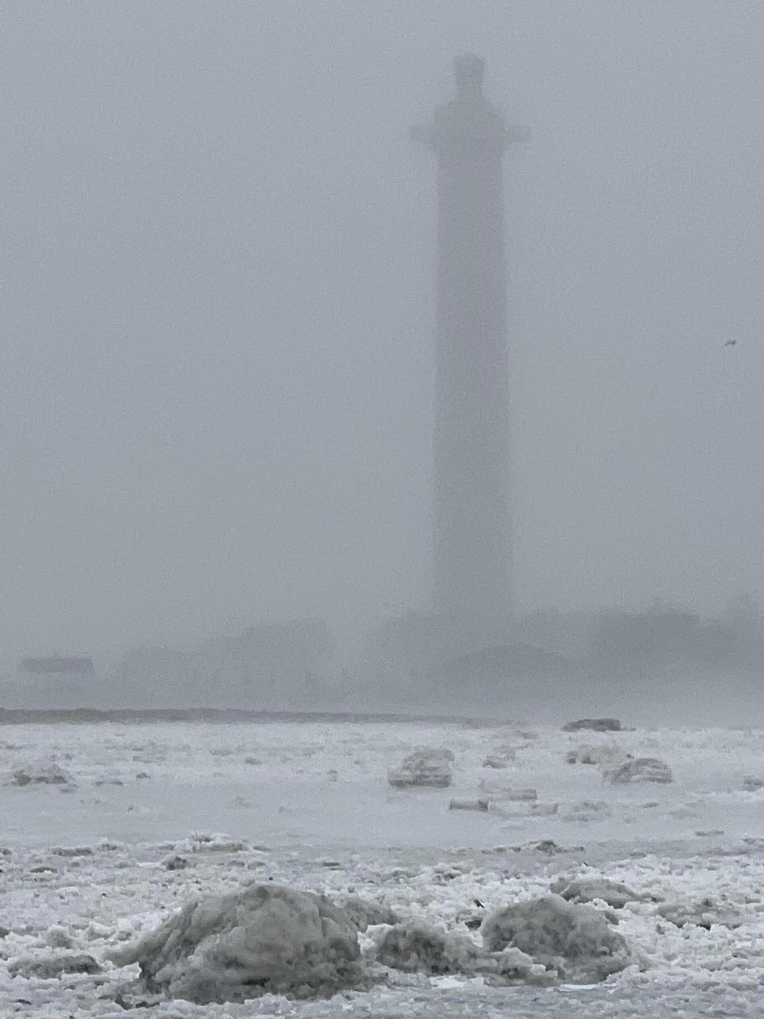 photo of the exposed lake erie shoreline with the perry monument in the background