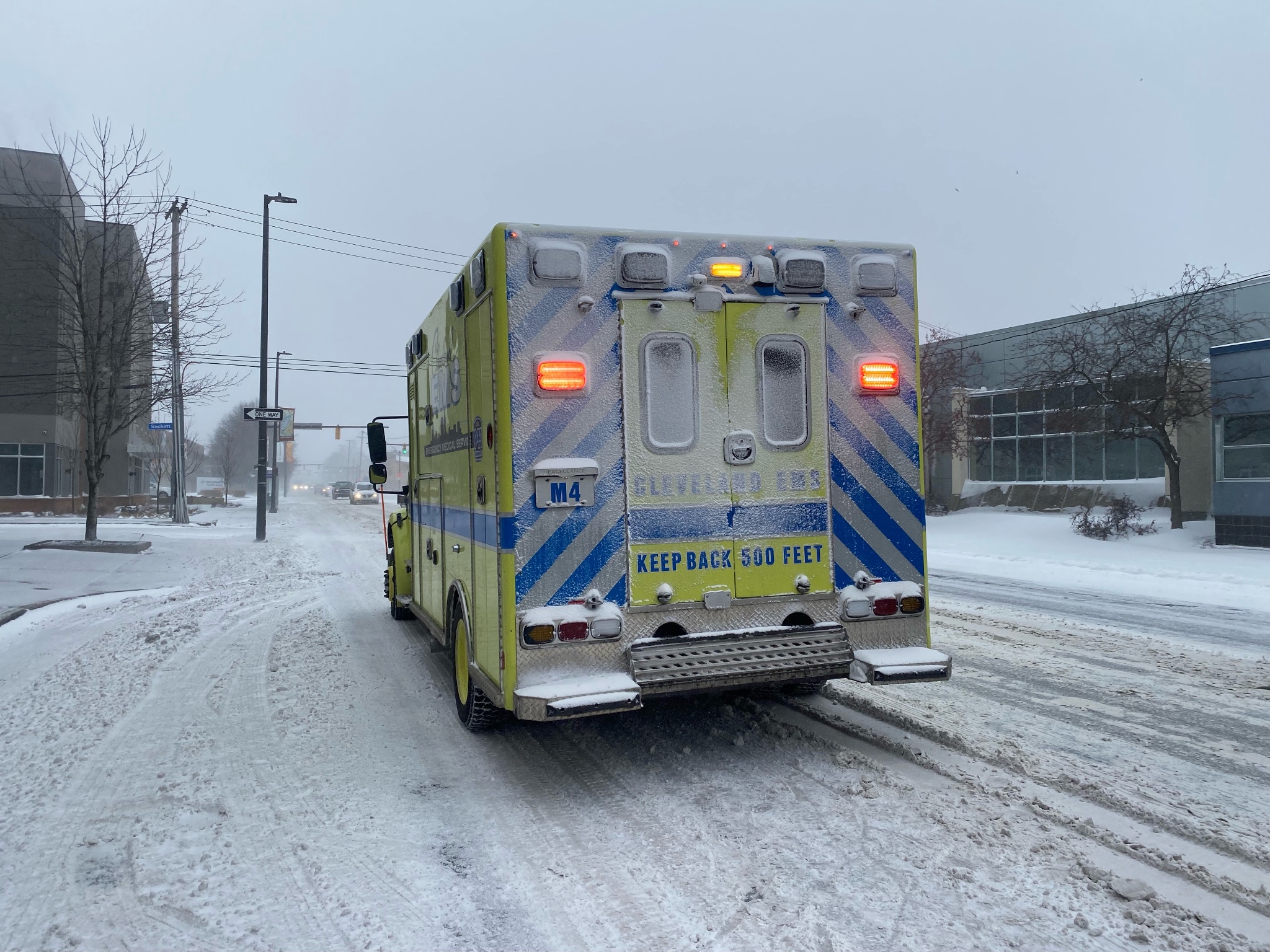 Photo of ambulance in Cleveland that is coated in ice on snow covered roads.