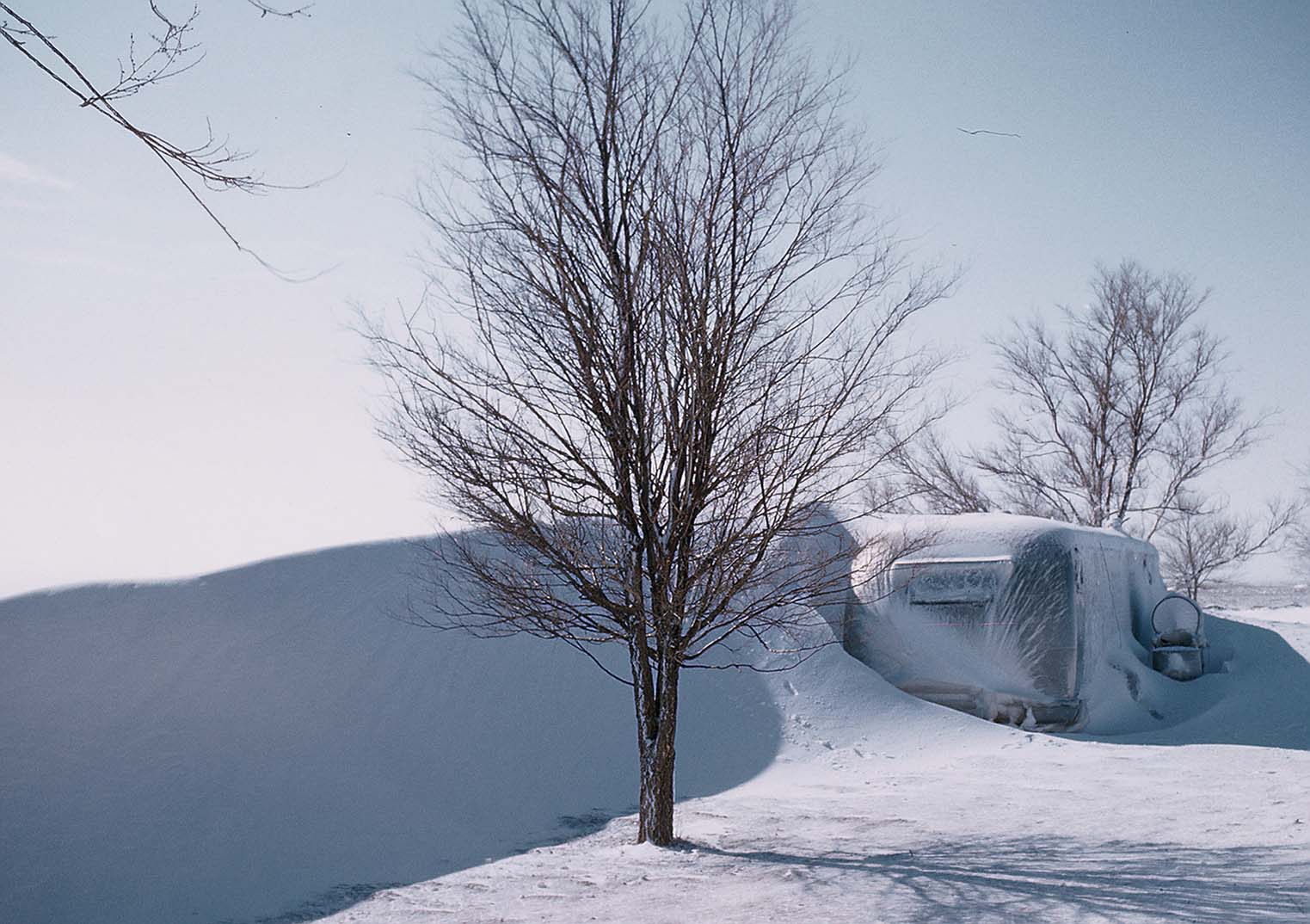 Trailer house with snow drift next to it.