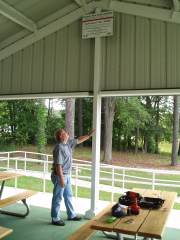 [ Rick Ullom, Hydrologist, Southeast River Forecast Center, looks at a high water mark sign installed at Legion Park. ]