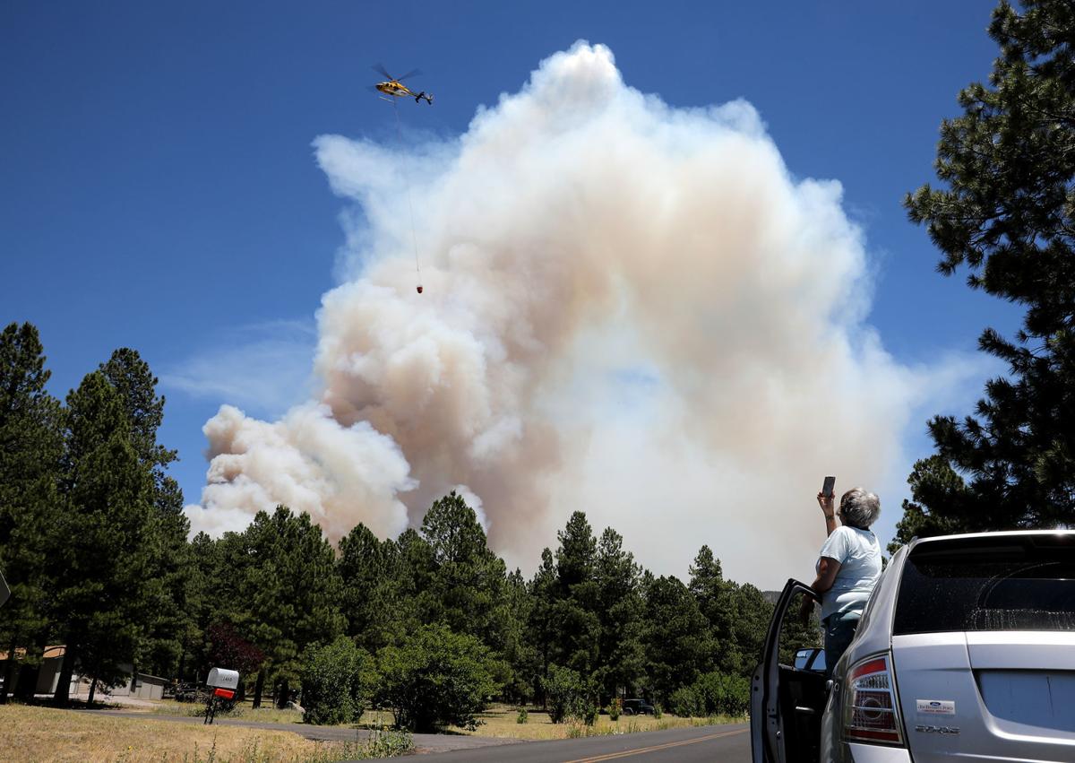 A helicopter being photographed taking water to the Museum Fire which will be used in suppression efforts.