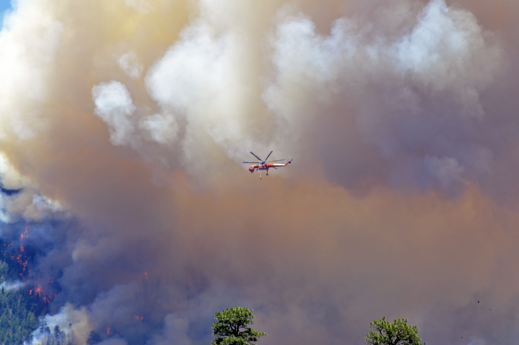 Helicopter flying in front of the smoke produced by the Schultz Fire. Photo credit: USDA Forest Service, Coconino National Forest