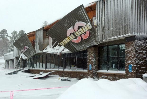 The facades of both Bookmans and Joann Fabrics hang off the front of the building after the roof collapsed late in the day on Thursday January 21st, 2010. This was due to the weight of snowfall that had fallen. Photo Credit: Josh Biggs