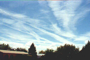 Image of the same contrails later in day showing how they spread out with time.
