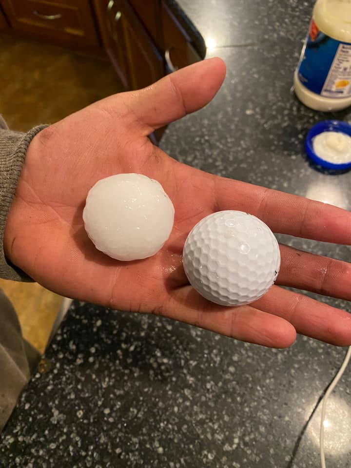 Hand holding golf ball next to a slightly smaller hail stone, Hatfield MN