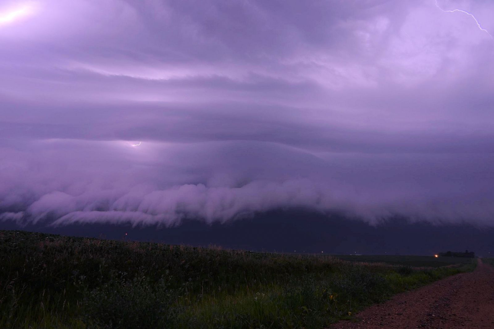 Photo of shelf cloud, dimly lit by in-cloud lightning, approaching Le Mars, Iowa, on the night of July 29-30, 2024