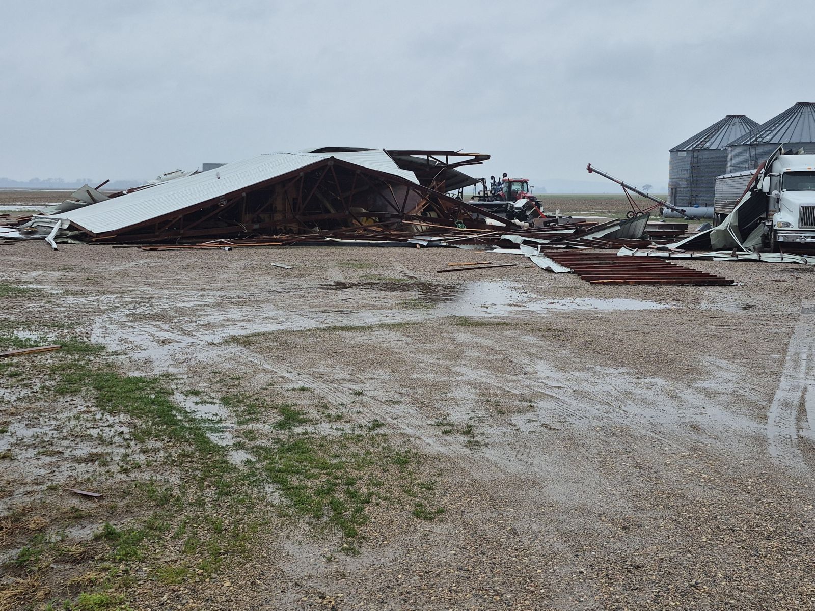 Thunderstorm Wind Damage Near Elk Point, SD. Photo shows a flattened pole-frame building with tin roof/siding.