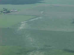 Aerial view of tornado path in field.