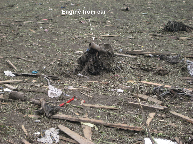 Picture of the car engine sitting in the middle of the field.