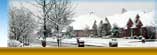 Picture of houses after snowfall. Snow covers roofs and street.