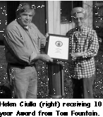 A picture of Mrs Helen Ciulla receiving a 10 year service award from Tom.