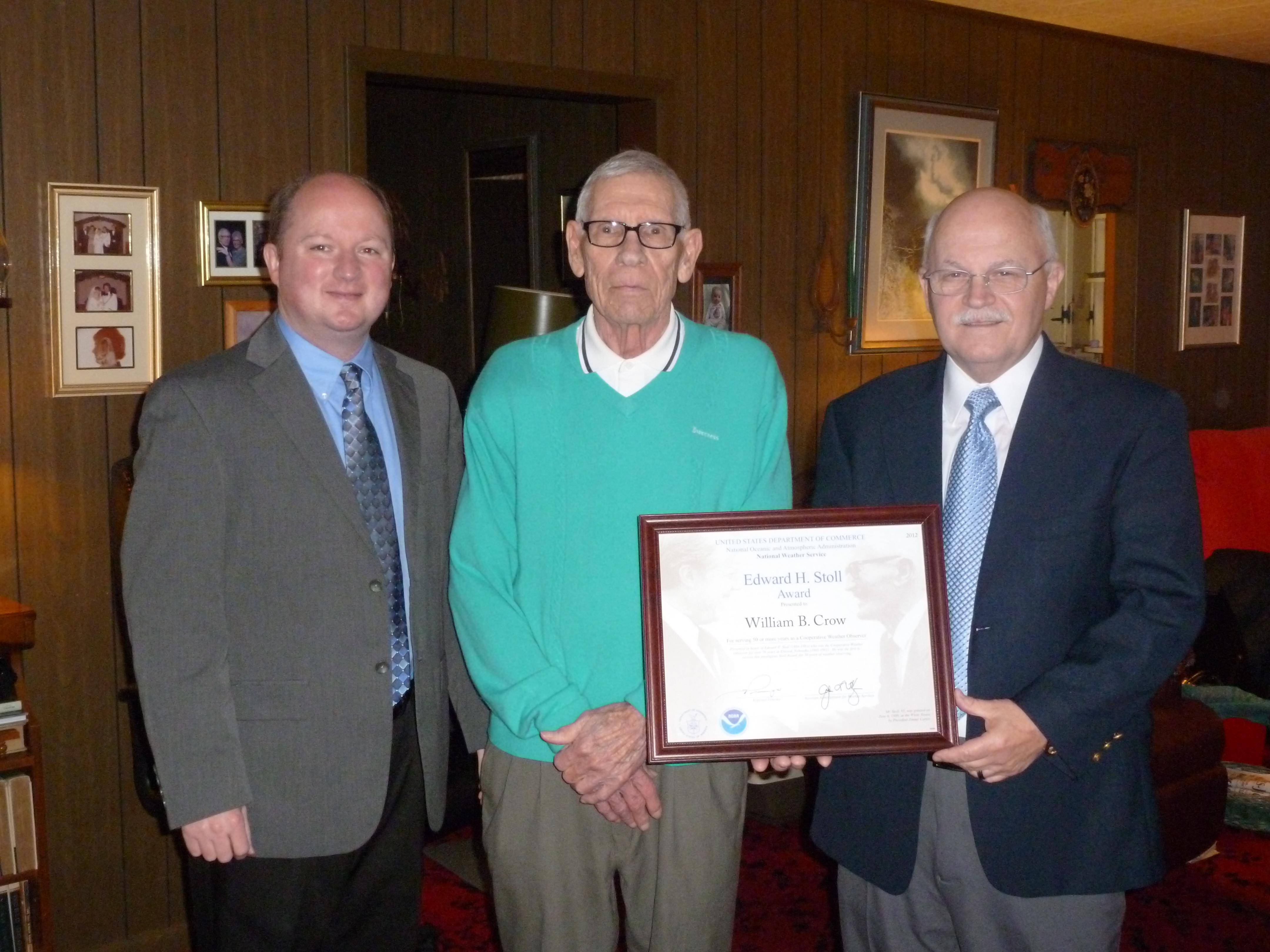Meteorologist Chris Darden and Observer Program Leader Lary Burgett present Mr. Crow with the Edward H. Stoll Award for 50 years of service