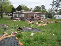 The roof of this home was damaged near the end of the tornado path. Insulation, shingles, and other debris were scattered by the tornado.