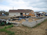 This house in the Stonebrook subdivision was lifted off of its foundation and moved several meters into its front yard. The left side of the house sustained significant damage and portions of the roof were also damaged (but were mostly left attached to the house).