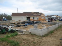 This house in the Stonebrook subdivision was lifted off of its foundation and moved several meters into its front yard. The left side of the house sustained significant damage and portions of the roof were also damaged (but were mostly left attached to the house). 