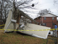 Mike Coyne, Meteorologist-in-Charge at the National Weather Service Office in Huntsville inspects damage to this shed near downtown Huntsville