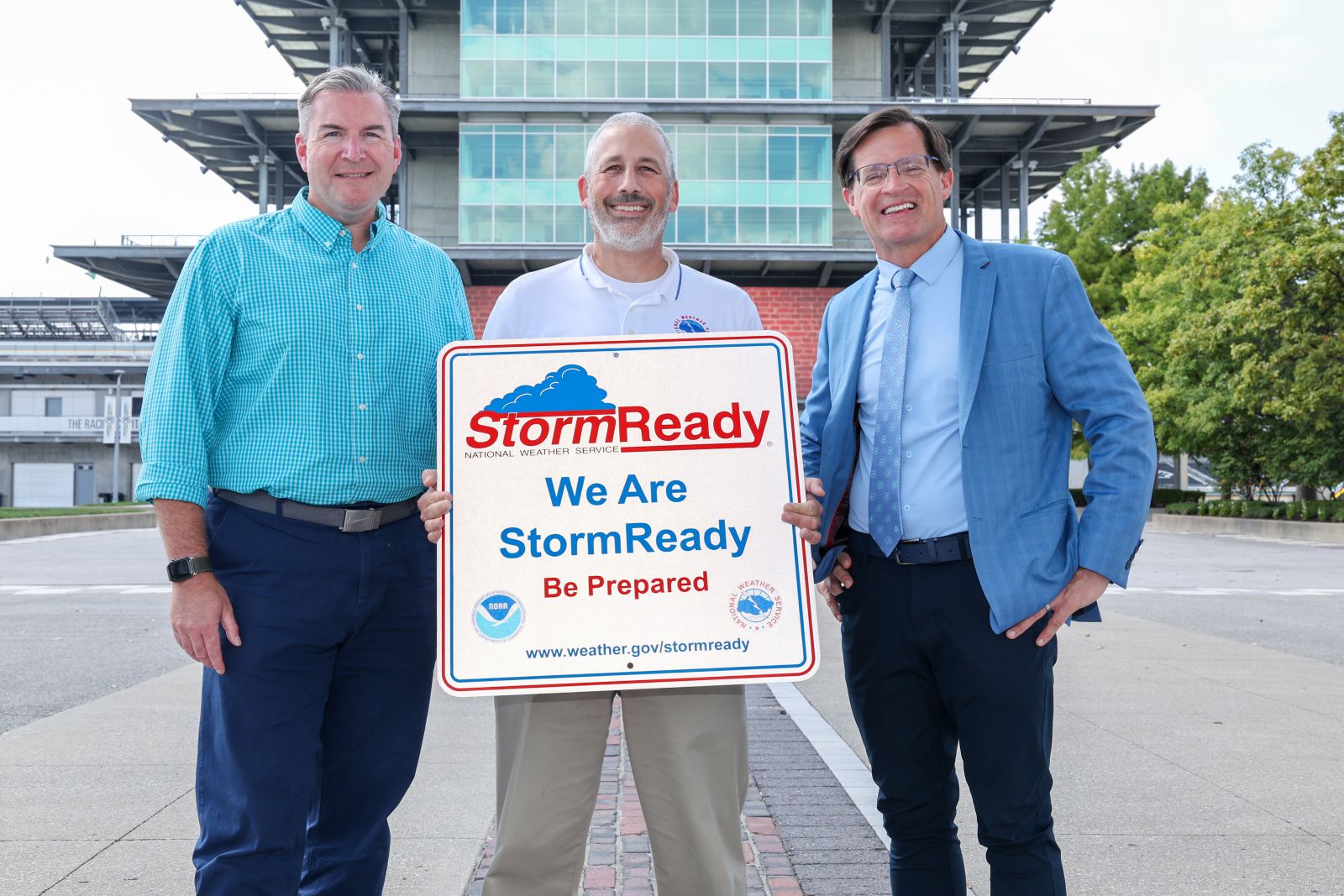 David Beachler, acting MIC for NWS Indianapolis and Mike Ryan present IMS President J. Douglas Boles with StormReady placard on the Yard of Bricks in front of IMS Pagoda Control Tower.