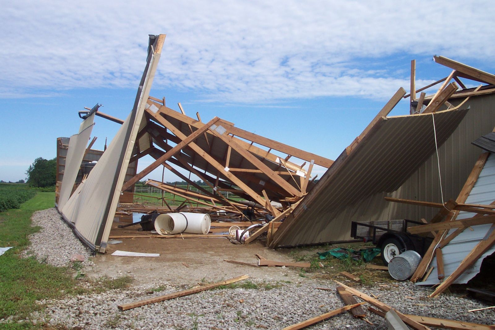 F2 damage to a barn. The barn door was left open, which allowed the wind to enter the structure and lift the roof off.