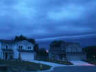 Another picture of the shelf cloud taken on July 3, 2001 around 5:12 a.m. Eastern Standard Time on the northwest side of Fort Wayne.  Notice the bright pink areas between the two houses.  This is a distant lightning strike.  Photo taken by Loretta Barlow.