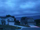 Another picture of the shelf cloud taken on July 3, 2001 around 5:12 a.m. Eastern Standard Time on the northwest side of Fort Wayne. Notice the bright pink areas between the two houses. This is a distant lightning strike. Photo taken by Loretta Barlow.