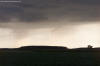 A very small funnel cloud on August 10, 2003
            at 7:47pm.  The photo was taken looking west from the intersection of
            Middle Point Road and Ringwald Road in Van Wert County.  The funnel
            is probably located around the intersection of Mendon Road and State Road,
            about three miles southeast of Van Wert, Ohio.  Photo courtesy Eric
            Germann.