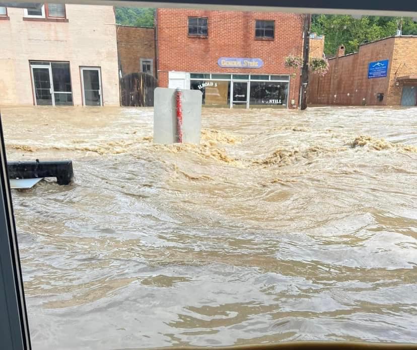 Several feet of flash flood water rushing down E Main Street (KY-15) in front of the Railroad Street Mercantile of downtown Whitesburg