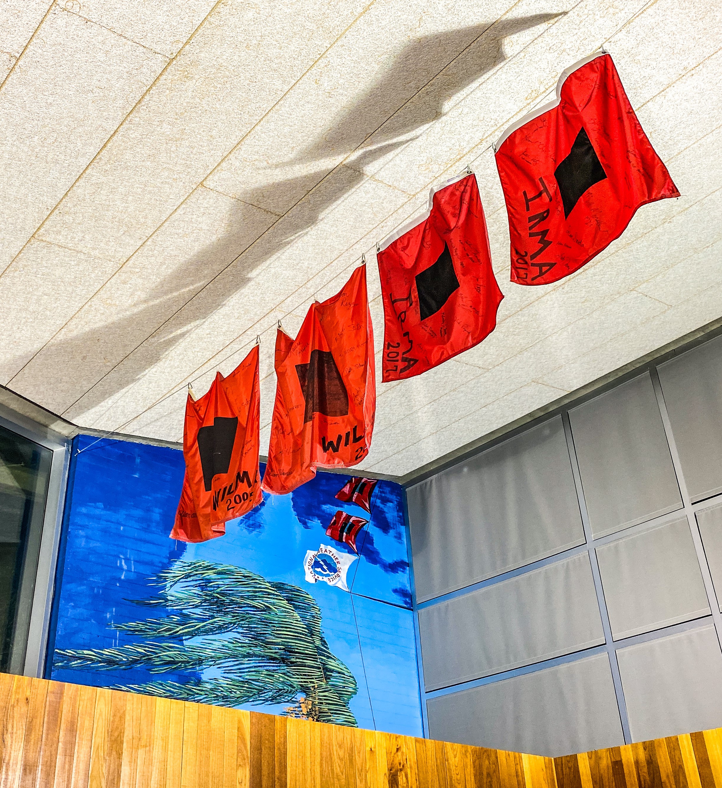 Picture of the office lobby mural and hurricane flags.