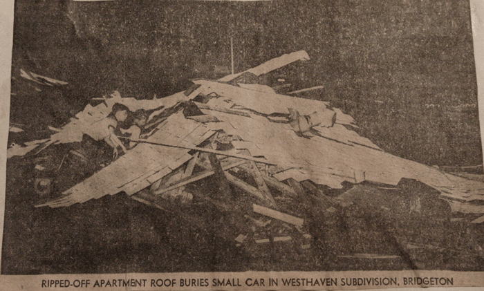 Photo of newspaper article with picture of a roof ripped off of a nearby apartment building that landed on a small car in Westhaven Subdivision in Bridgeon, MO.