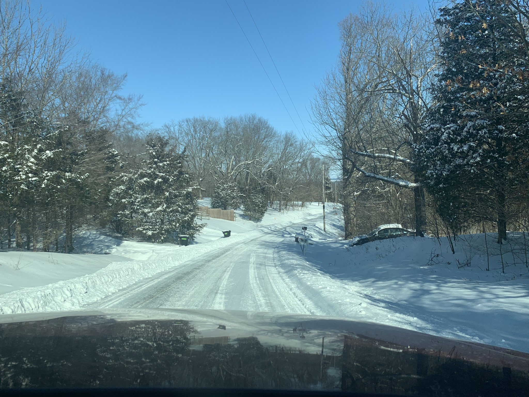 Photo of a sunny and snowy drive.