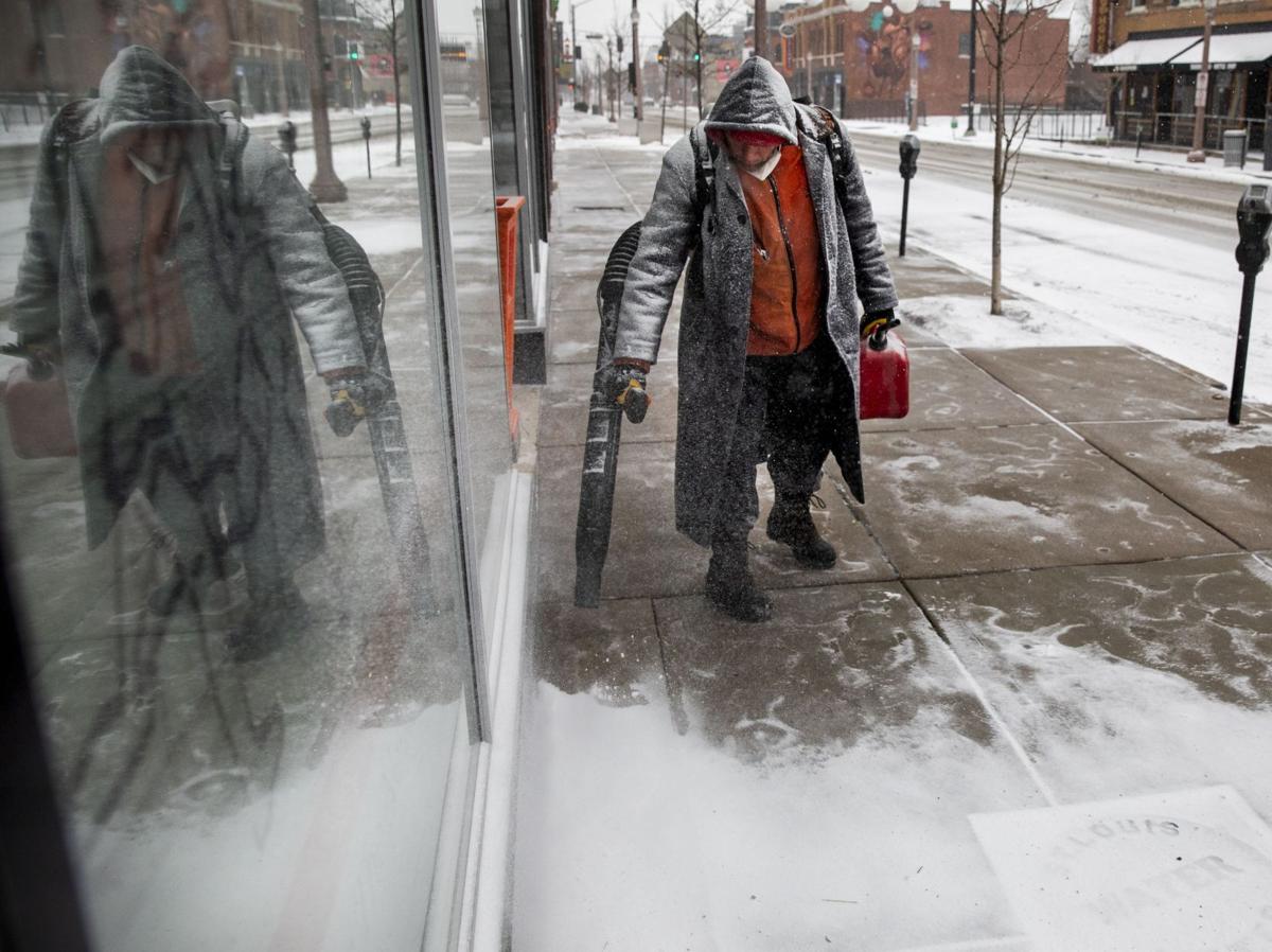 Photo of someone clearing snow with a leaf blower.