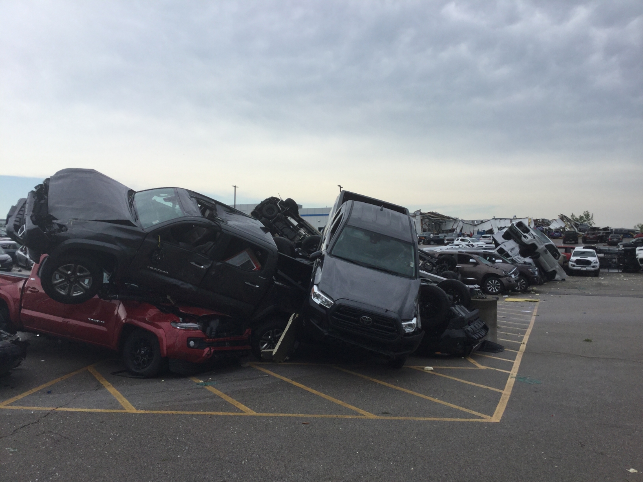 Photo of cars that were tossed into piles at a car dealership by 130 mph winds.