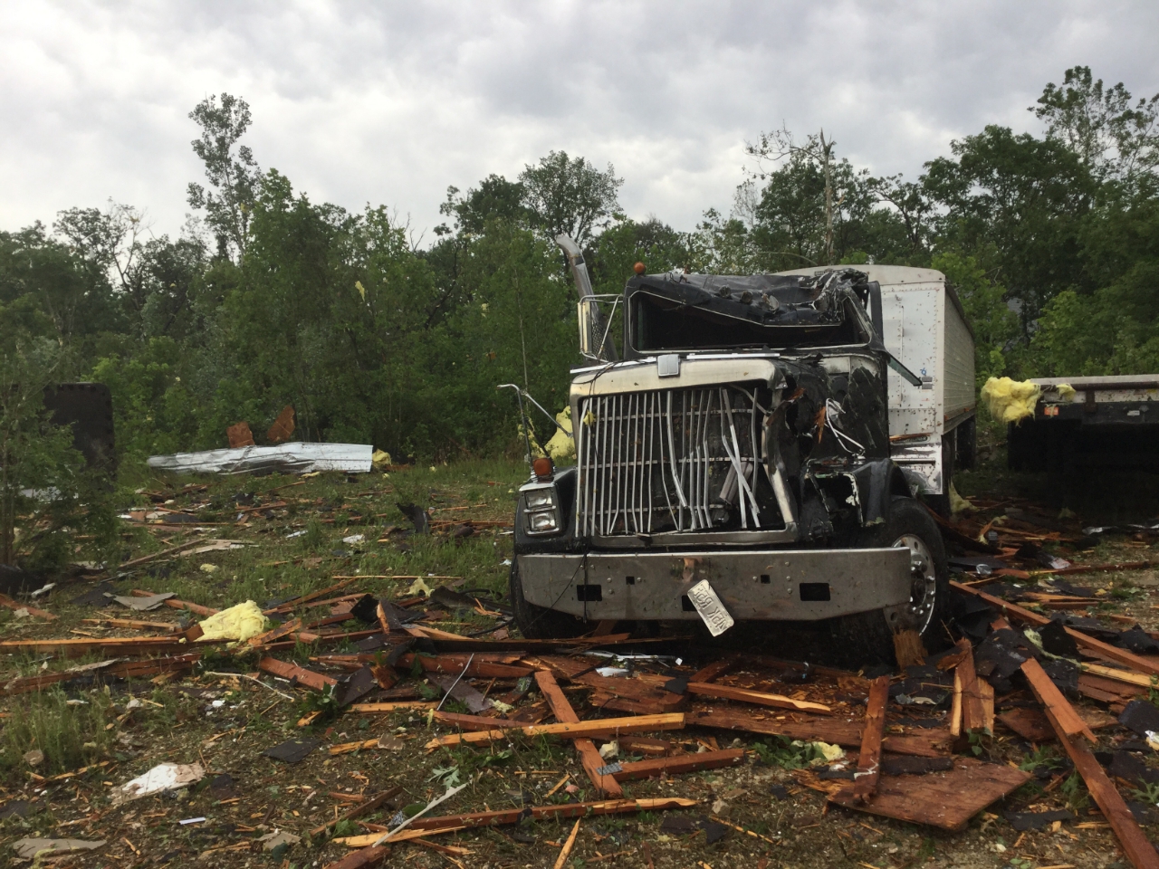 Photo of semi truck that was damaged from flying debris from a nearby office building.