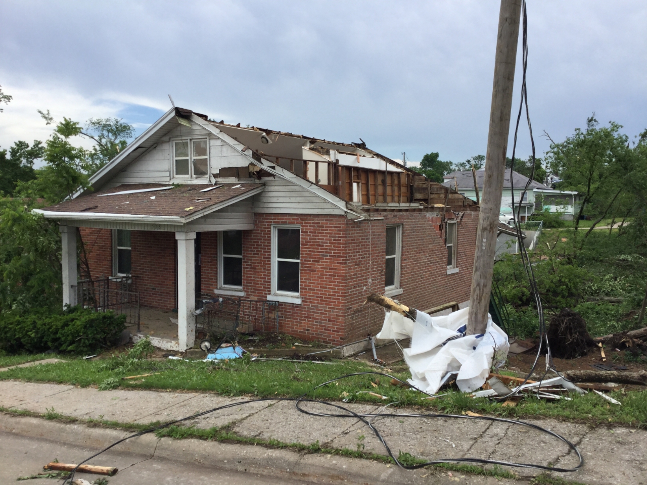 Photo of house with half of roof missing.