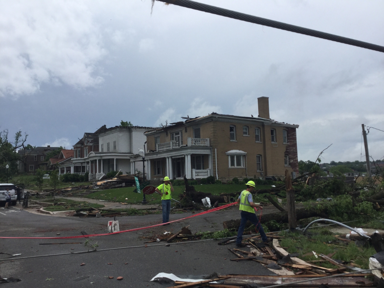 Photo of homes with roof damage and numerous windows broken.