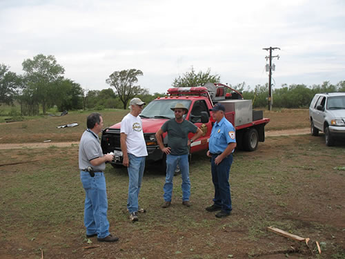 National Weather Service Meteorologist and Information Technology Officer John Holsenbeck (left) discusses damage information with Paducah Emergency Management Coordinator and Fire Chief Randy Detwiler (right) and local members of the community.